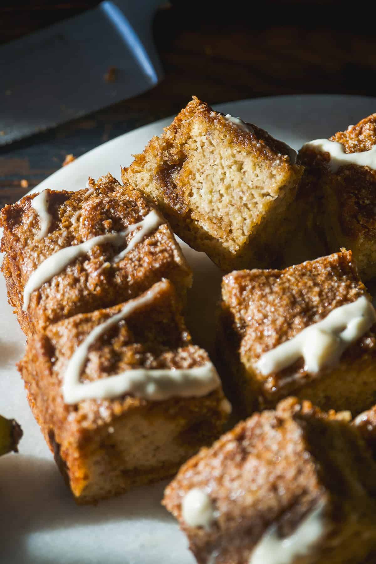 Coffee cake with banana cut into pieces and scattered on a platter.