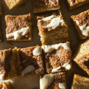 Overhead view of banana coffee cake on a platter with crumble and icing on top.