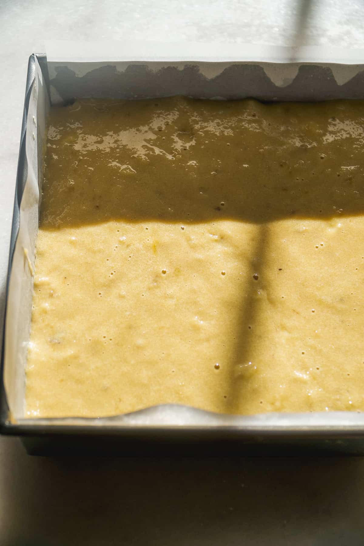 Banana coffee cake batter layered in a pan.