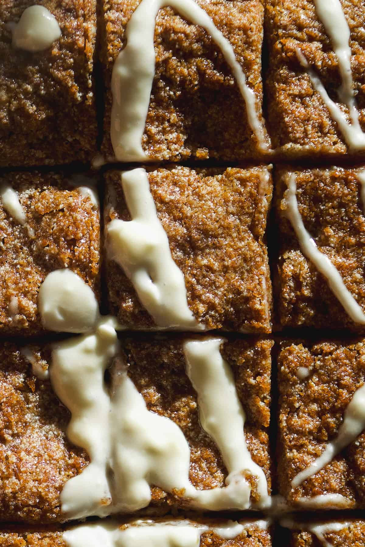 Coffee cake with banana cut into squares with icing on top.