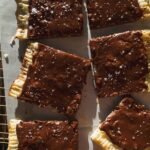 Overhead view of chocolate pop tarts cut into pieces on a wire rack.