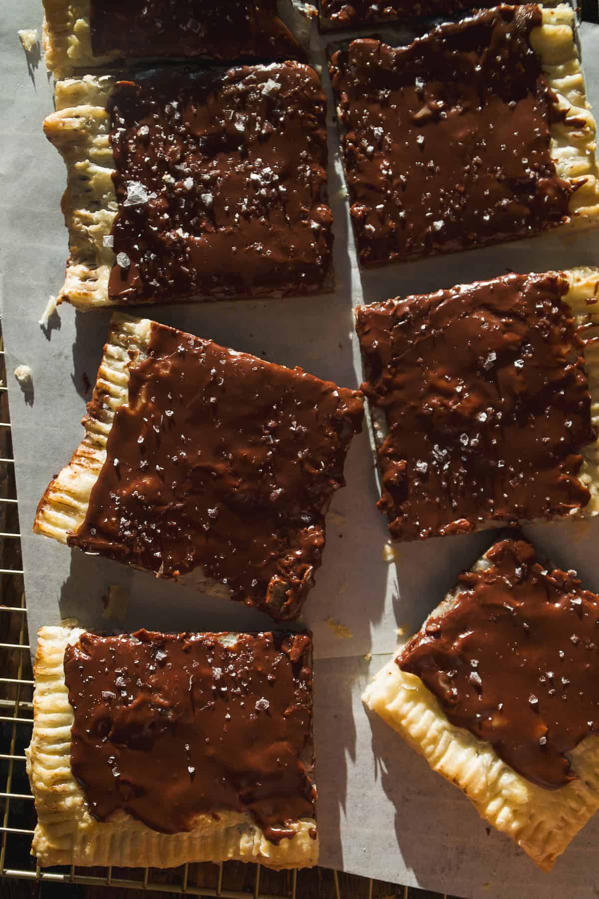 Overhead view of chocolate pop tarts cut into pieces on a wire rack.