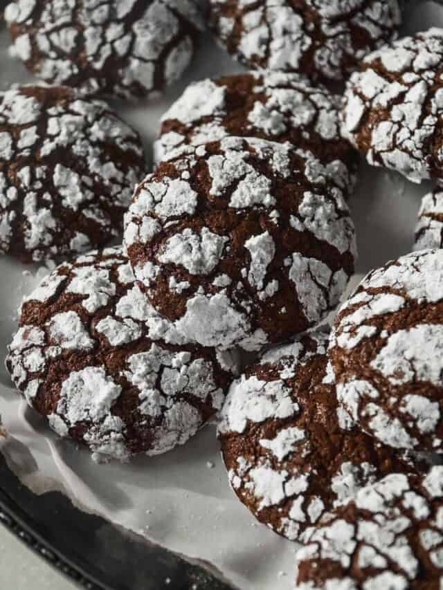 Chocolate crinkle cookies baked and piled on a platter.