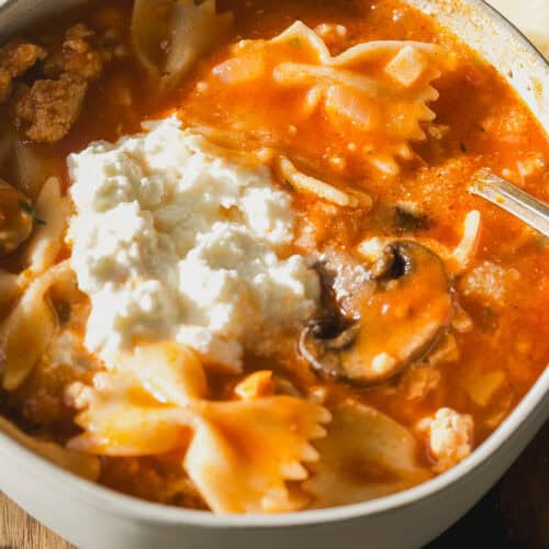 Lasagna soup in a bowl with pasta, mushrooms, and ricotta cheese.