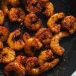 Cast iron skillet with cajun shrimp.