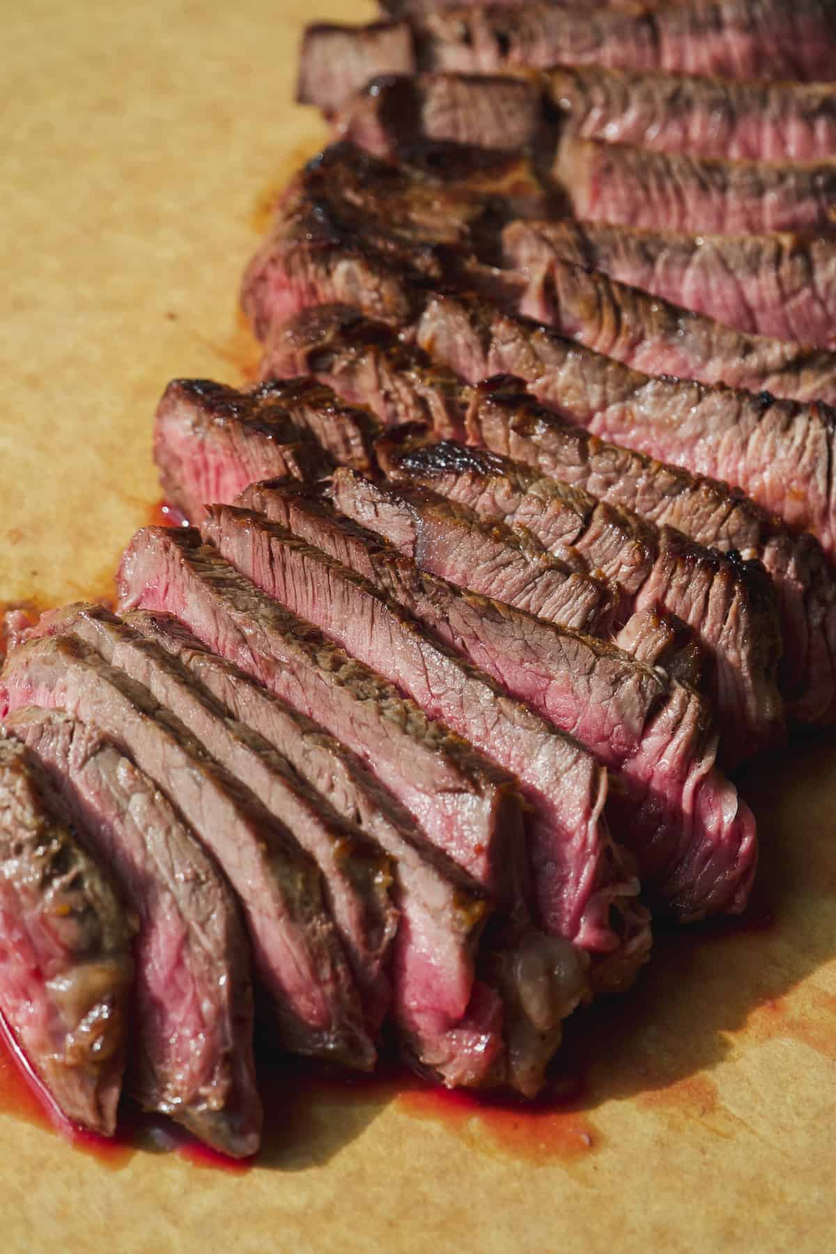 Steak cut into strips on a cutting board.