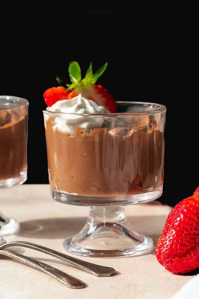 Side view of dairy free chocolate pudding topped with strawberries.