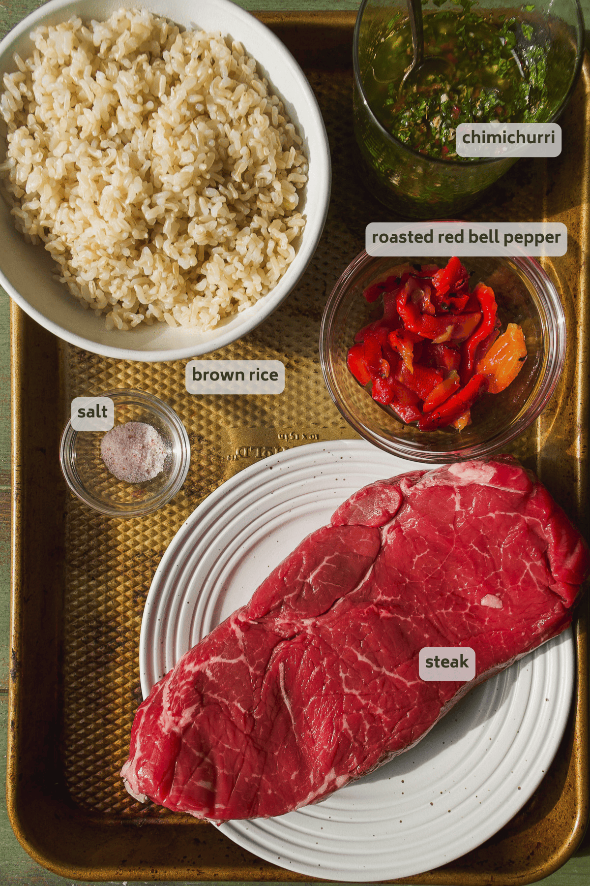 Chimichurri steak rice bowl ingredients on a pan with labels.