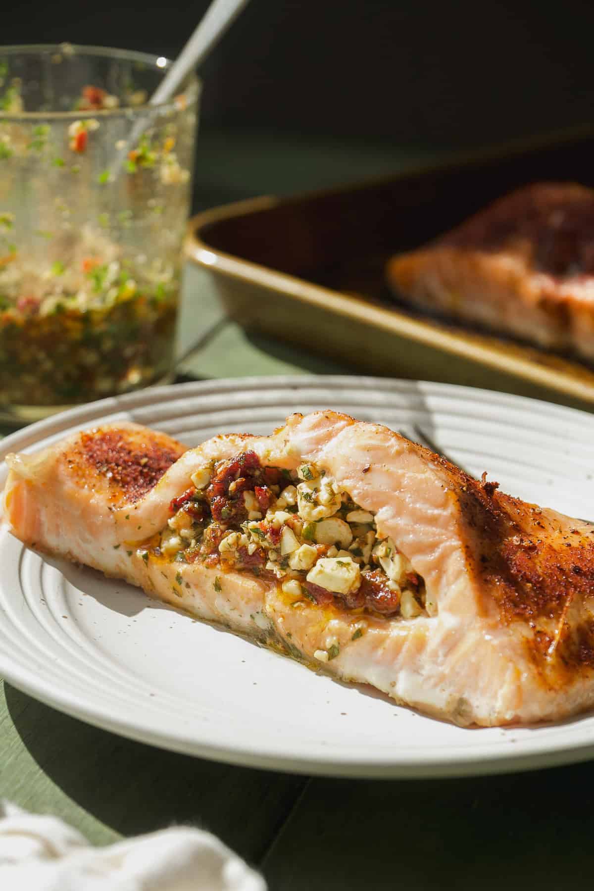 Stuffed salmon with feta and sun dried tomatoes on a plate.