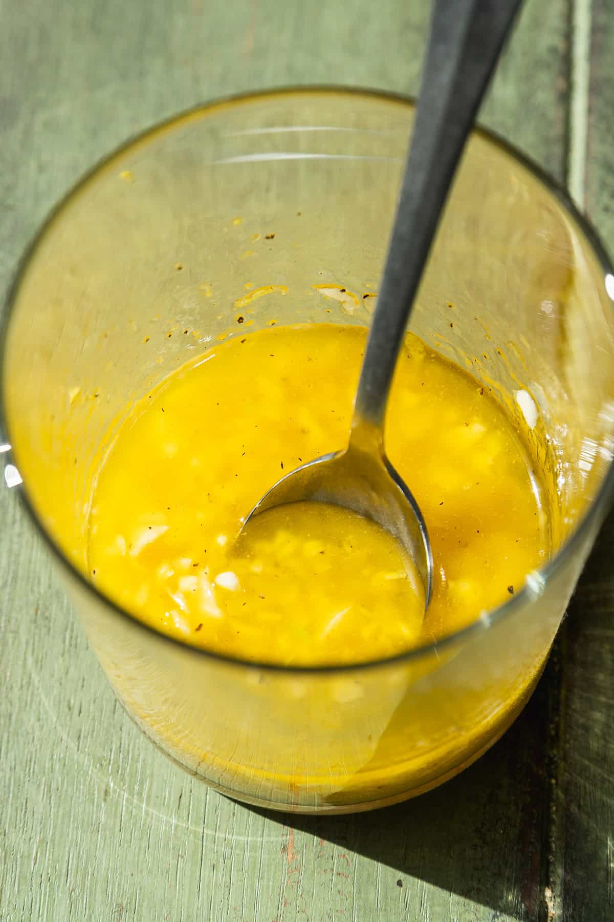 Butter garlic mixture in a jar with a spoon.