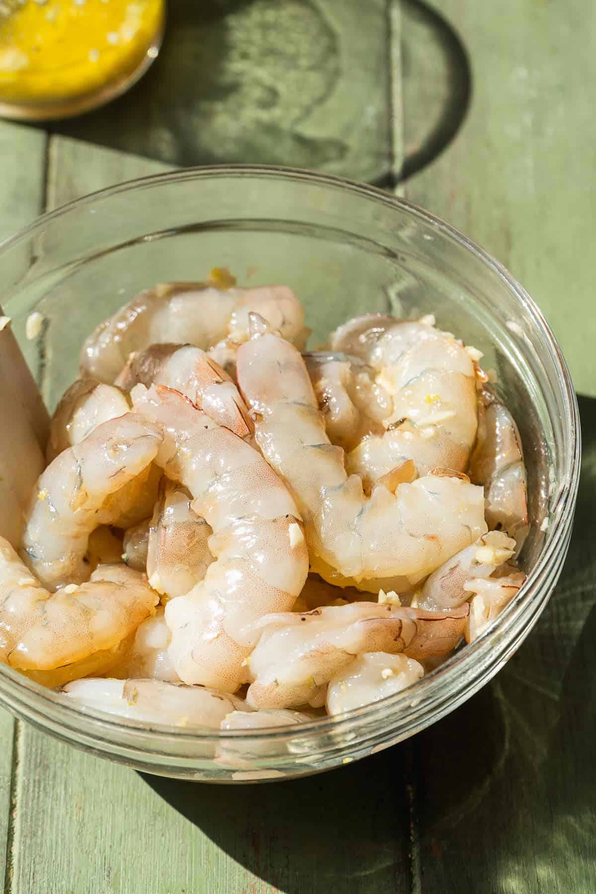 Shrimp in a bowl with garlic and seasonings.