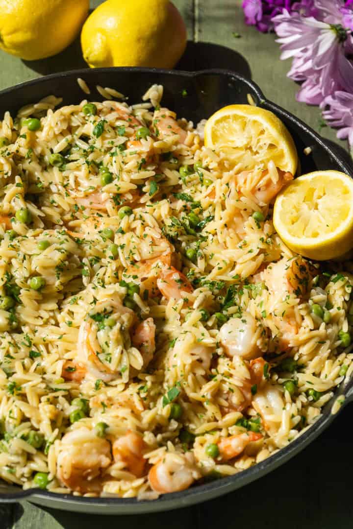 Lemon garlic butter shrimp with orzo in a skillet.
