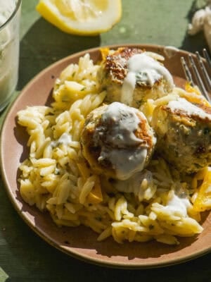 Greek chicken meatballs on top of lemon orzo.