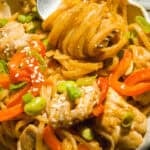 Almond butter noodles in a bowl with a fork.