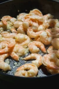 Shrimp cooking in a cast iron skillet.