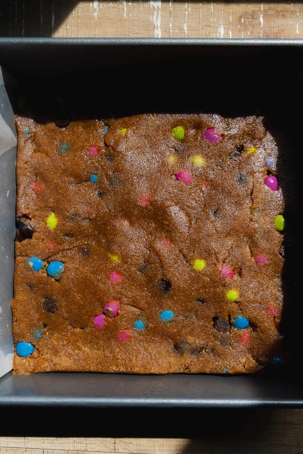 Monster cookie bars about to be baked in a baking dish.