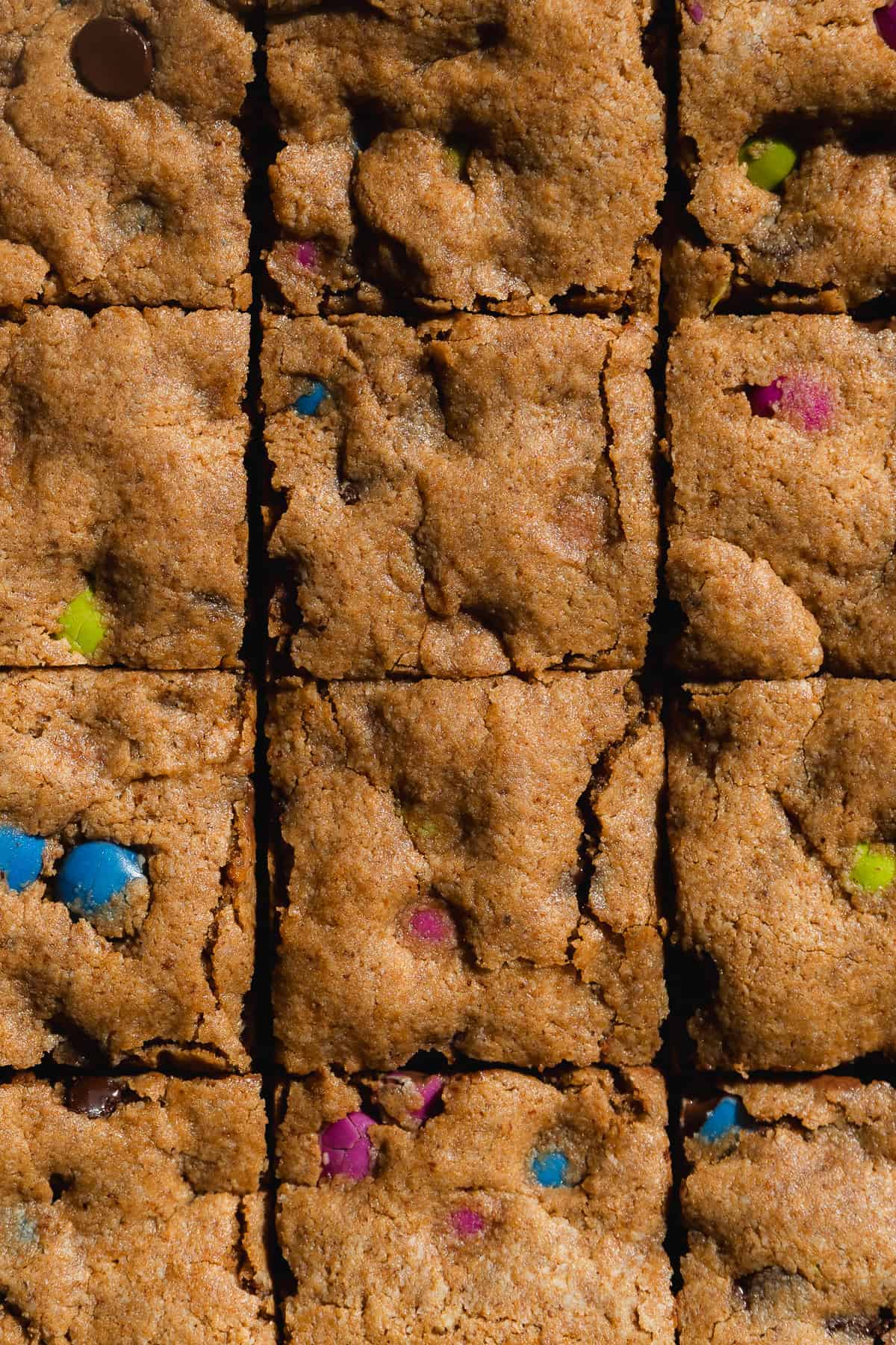 Cookie bars with multicolored candies cut into squares.