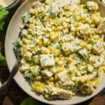 Creamy corn salad with greek yogurt in a bowl with a fork.