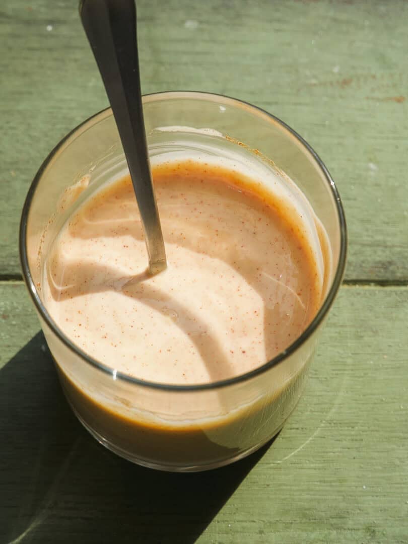 A glass with a spoon in it.