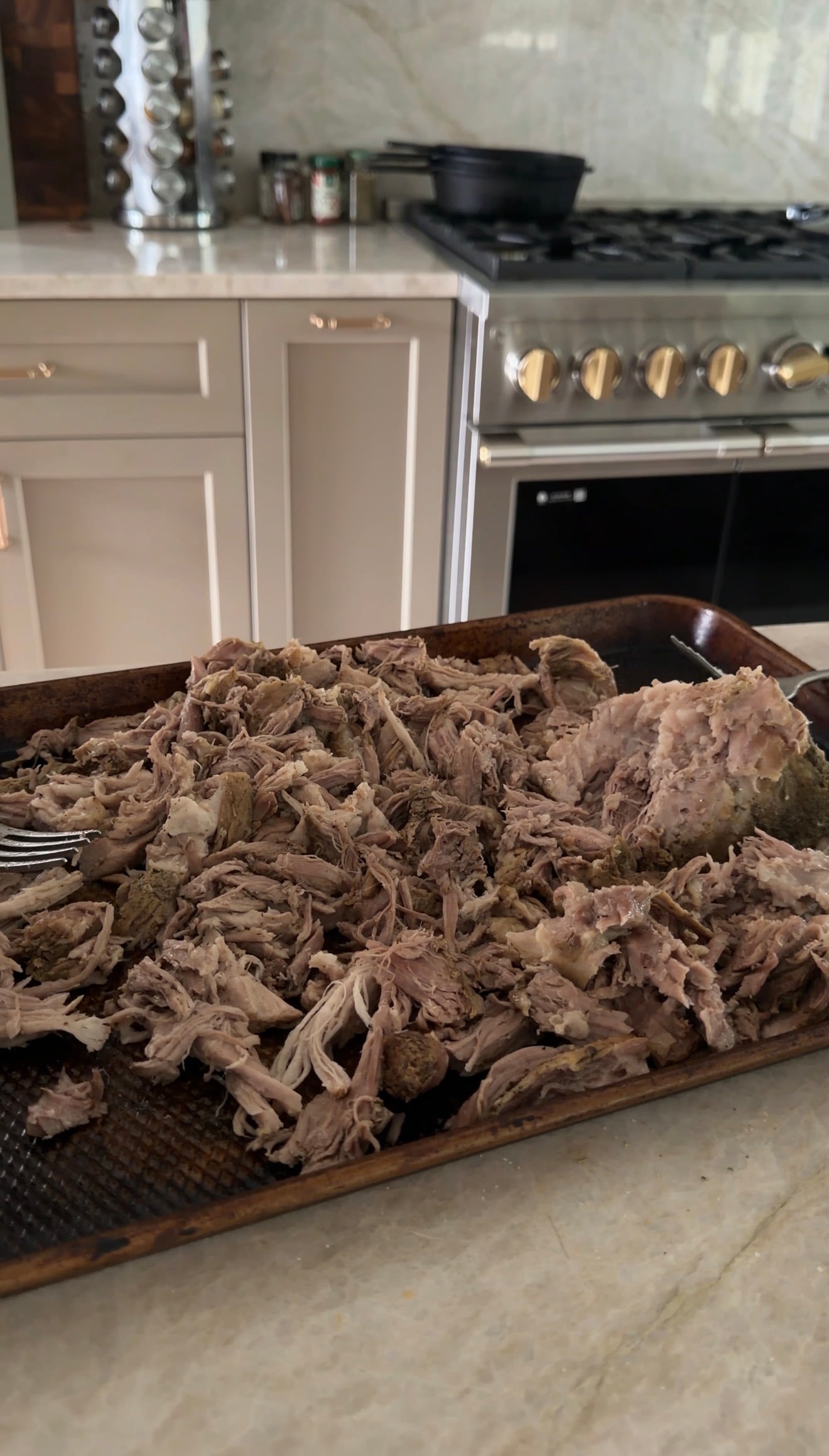 A large baking sheet filled with shredded pulled pork.