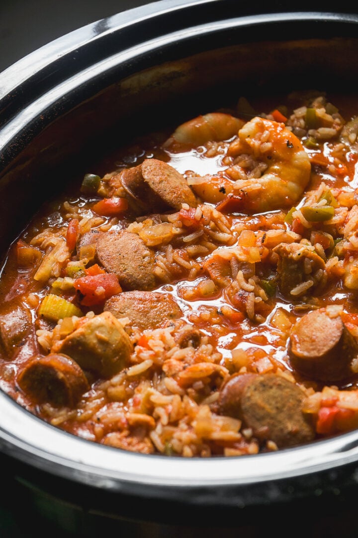 Jambalaya with shrimp, sliced sausage, and rice in a slow cooker.