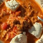 Lasagna soup in a patterned bowl topped with three dollops of ricotta cheese.