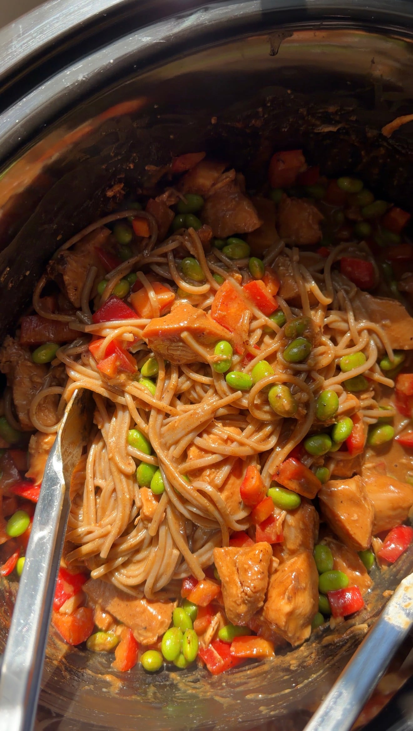 Noodles tossed with chicken, edamame, and red bell peppers in a slow cooker.