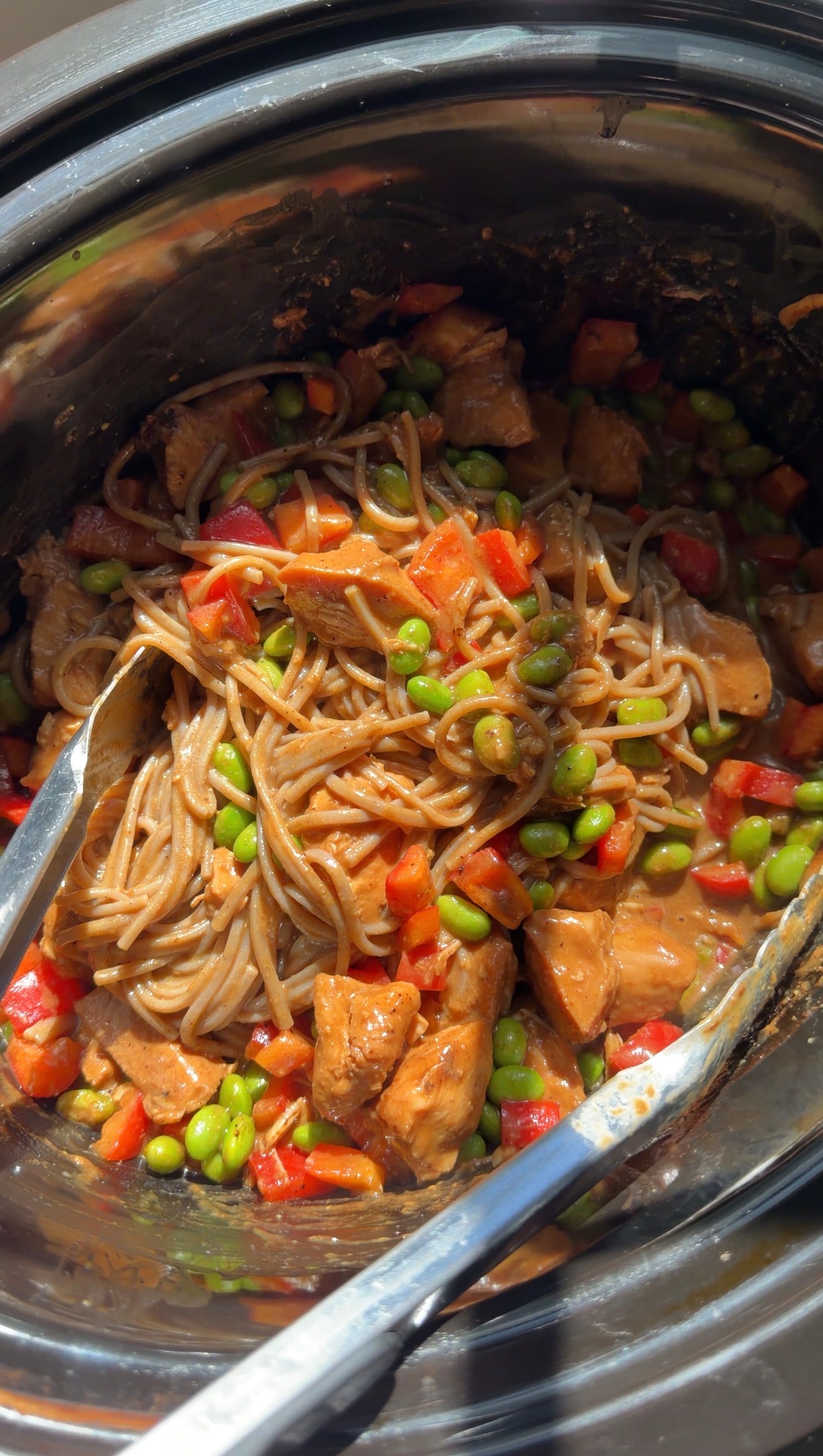 Slow cooker pasta with chicken, edamame, and red bell peppers in a creamy sauce.